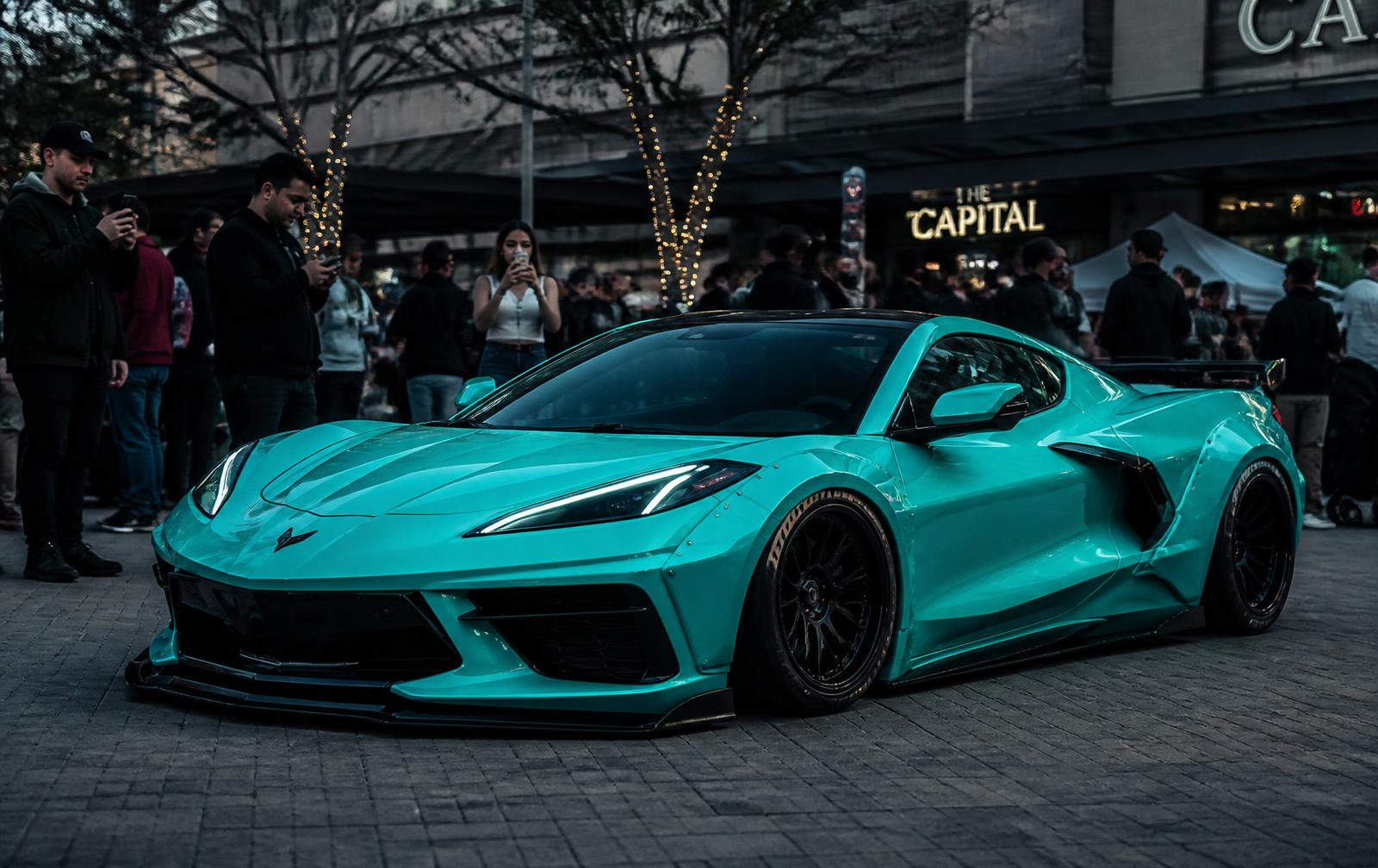 People stopping, pointing and photographing the Tiffany-blue widebody C8 Corvette in a public plaza