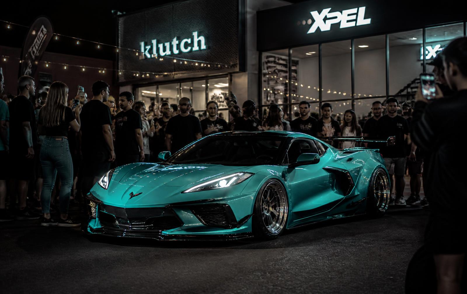 Crowd gathered around the Tiffany-blue widebody C8 Corvette at a night brand activation